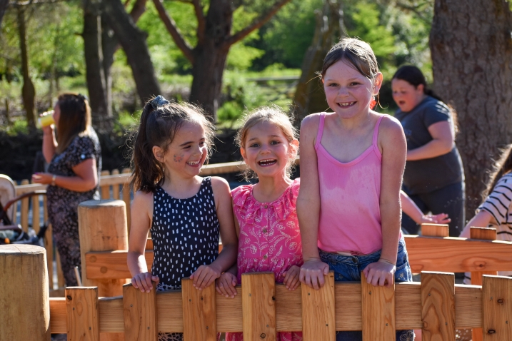 Three friends stood on a bridge at paddle and play Martin Mere